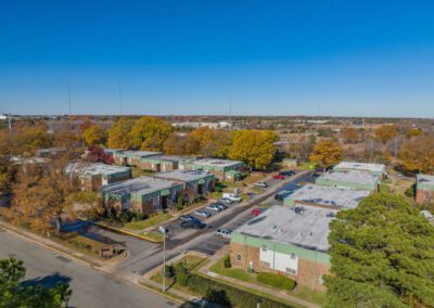 Aerial view of a vibrant apartment complex surrounded by colorful autumn foliage, showcasing the beauty of fall.